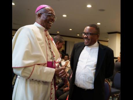Men of faith  Archbishop Kenneth Richards (left), Roman Catholic Archdiocese of Kingston, and Reverend Father Rohan Tulloch, acting Jesuit Superior, enjoy a humorous moment. 
