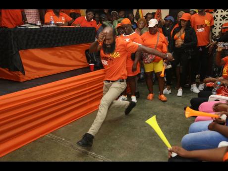 A frenzied PNP supporter dashes across the floor during the Clarendon Northern constituency conference held Sunday at Claude McKay High School in James Hill. 