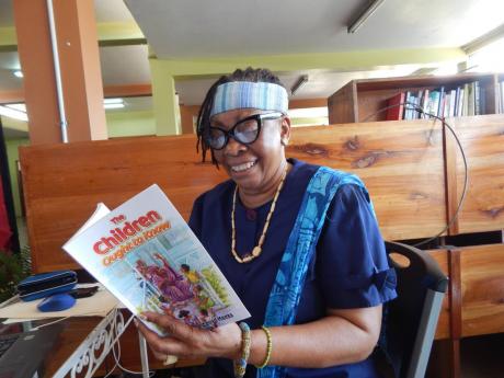 Dr Amina Blackwood Meeks smiles broadly as she peruses her just-launched book.