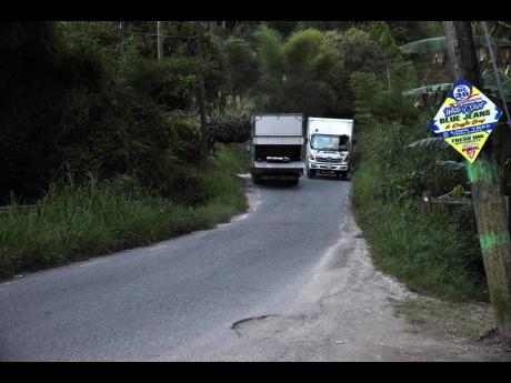 One truck exits the single-lane bridge in Borobridge, St Ann, on Wednesday as another approaches. Residents say there are frequent accidents and near misses in the area, which is traversed by many visitors who are unfamiliar with the route.