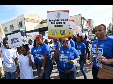 Rosalee Gage-Grey (second right), CEO of the Child Protection and Family Services Agency (CPFSA), marching with children and other participants in the ‘Stop the Silence, End the Violence’ islandwide children’s march and remembrance rally from the St 
