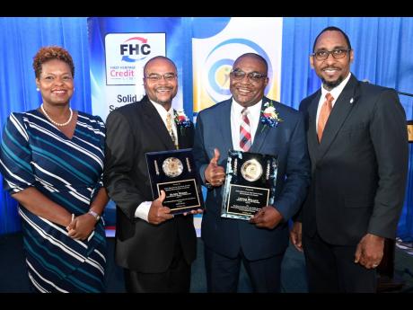 Roxann Linton (left), CEO of First Heritage Co-operative Credit Union (FHC), and O’Neil Grant (right), president of Jamaica Civil Service Association, flank Civil Servant of the Year awardees Oliver Morris (second left) of the Administrator General’s D
