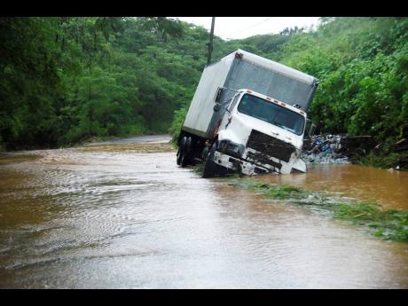 In this September 2022 photo, a truck is stuck on Chapelton Road in Clarendon after it fell into a trench on the flooded roadway. Several roads were impossible with the passage of Tropical Storm Ian, which developed into a hurricane and made landfall in Fl