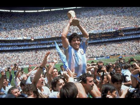Diego Maradona, holds up the trophy, after Argentina beat West Germany 3-2 in the World Cup soccer final match, at the Atzeca Stadium, in Mexico City on June 29, 1986. 