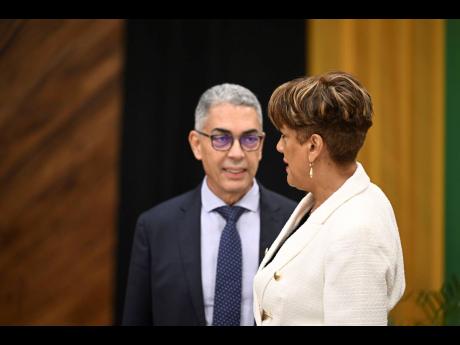 Governor of the Bank of Jamaica Richard Byles speaks with Deputy Governor Natalie Haynes, at the BOJ quarterly monetary press briefing on Friday, November 18, 2022.