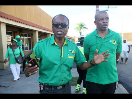 Joel Williams (left), councillor for the Denbigh division and heir apparent to Clarendon Central Member of Parliament Mike Henry, is seen alongside Kenneth Davis, councillor for May Pen East, as they organise JLP supporters for the annual conference. 