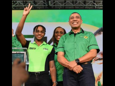 Prime Minister Andrew Holness and wife Juliet Holness introduce their son, Matthew, to suppporters during the Jamaica Labour Party's 79th annual conference at the National Arena on Sunday.