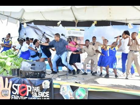 Minister Without Portfolio in the Office of the Prime Minister Floyd Green (centre) is joined by students in a dance exercise following a Child Protection and Family Services Agency child abuse sensitisation march in Black River on November 18.