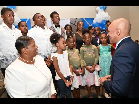Major General Antony Anderson (right), commissioner of police, and Bobette Morgan-Simpson (left), superintendent of police in charge of St Mary, talk with the children of fallen cops who were fêted at a luncheon at The Jamaica Pegasus hotel in New Kingsto