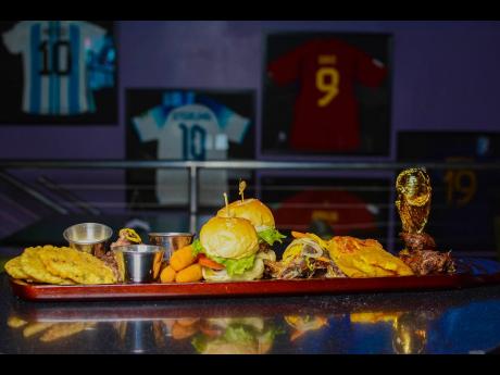 Above: The vibes of the Bellyful platta include a hefty serving of a variety of dishes including  jerked chicken wings, jerked  pork, sprat, two beef sliders, pressed green plantains, fritters, mozzarella sticks and a mac and cheese pie. 