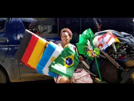 Rushana Brown shows off her stock of flags at her stall on Orange Street, Kingston.