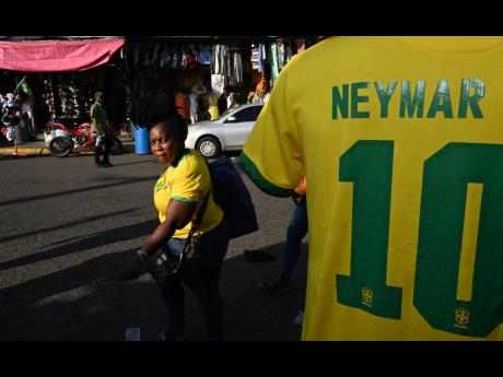 A Brazil supporter walks by a Neymar jersey on Beckford Street in downtown Kingston on Thursday.