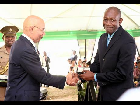 Sir Patrick Allen, (left) governor general of Jamaica presents O’Neil Anthony Hamilton, veteran staffer of the office of the governor general with his award at the Jamaica Civil Service long service recognition ceremony at Kings House on Wednesday, Novem