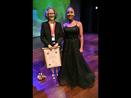 Winning the Musgrave gold medal for literature is Diana McCaulay (left), author and environmental activist, posing with Emprezz Golding at the ceremony.