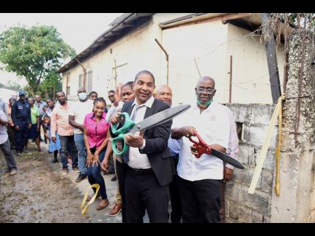 Desmond McKenzie (right), minister of local government and rural development, cuts the ribbon with Kingston Mayor Delroy Williams 
            to open the new sanitary convenience at the Stony Hill Market in St Andrew on Thursday.