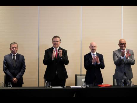 From left, Venezuelan opposition delegate Gerardo Blyde Perez, Mexico’s Foreign Minter Marcelo Ebrad, Norwegian diplomat Dag Nylander and President of the National Assembly of Venezuela, Jorge Rodriguez, applaud after signing an agreement to create a UN-