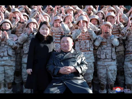 North Korean leader Kim Jong Un, centre right, and his daughter, with soldiers, pose for a photo, following the launch of what it says a Hwasong-17 intercontinental ballistic missile, at an unidentified location in North Korea. 