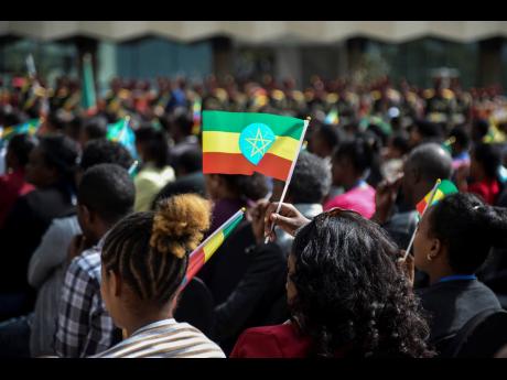 A member of the audience holds a national flag at a ceremony to remember those soldiers who died on the first day of the Tigray conflict, outside the city administration office in Addis Ababa, Ethiopia on November 3.