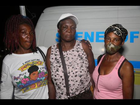 Hyacinth Brown (centre), mother of Clayton Pink, is support by her daughter, Marilyn Graham (left), and cousin Hyacinth Smith, aunt of Jerome Smith. Both men were shot and killed, allegedly by a police constable, in Frankfield, Clarendon, on Saturday. 