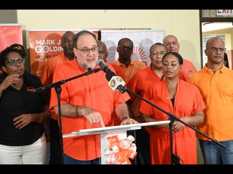 Surrounded by senior People’s National Party members, Opposition Leader Mark Golding addresses journalists during a post-National Executive Council press conference at Spanish Town Primary on Sunday.