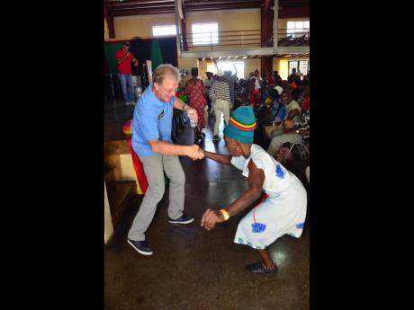 Rotarian Mathew Pragnell dances with a one-legged senior at the 2019 staging of the Rotary Club of Kingston’s annual senior citizens’ Christmas treat, which was hosted at The Wolmer’s Boys’ School auditorium.