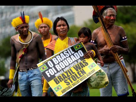 A family of Kayapo Indigenous people arrive to take part in a protest by supporters of Brazilian President Jair Bolsonaro against his presidential election loss in Brasilia, Wednesday, November 30.