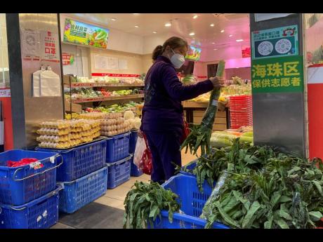 A woman shops in a reopened grocery store in the district of Haizhu as pandemic restrictions are eased in southern China’s Guangzhou province yesterday.