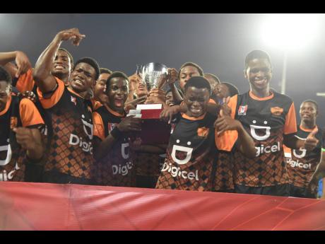 Tivoli High School's players celebrate winning the Walker Cup Trophy after a 6-5 penalty win against Haile Selassie at Sabina Park earlier this evening.