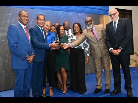 Dr Nigel Clarke (left), minister of finance and the public service and Keith Duncan (right), president of PSOJ present the Greta Bogues Award for excellence in Corporate Governance to Lyttleton Tanny Shirley (second left), chairman of Factories Corporation