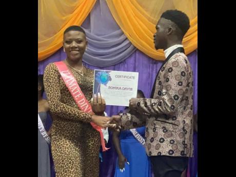 Tayjaun Banner, director of the Mr and Miss Central Jamaica pageant, presents an award to Sonika Davis, a participant in the competition held at the Bishop Gibson High School in August 2022.