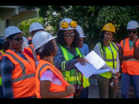 Lauren Peters (centre), managing director of Nuance Security and Solar Systems Ltd, guides the trainees during a practical on the key concepts of electricity and safety practices when installing and wiring solar photovoltaic panels during a training semina