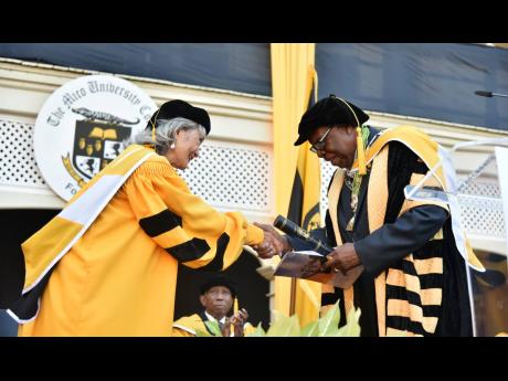 Island Grill restaurateur Thalia Lyn (left) accepts an honorary doctorate from chancellor of the Mico University College, Dr Karl James, on Thursday.