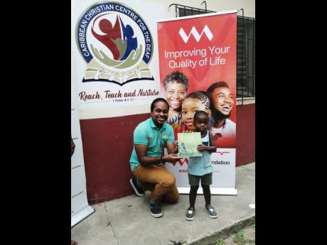 With the help of his mother, Ayedin (right) seals the deal with Andre Witter of the Ready to Sign group to release the Jamaica sign language version of the Ayedin Learns next year. 