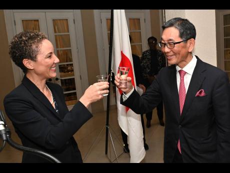 
It was saké time for Minister of Foreign Affairs and Foreign Trade, Kamina Johnson Smith (left) who made a toast to Ambassador of Japan, Masaya Fujiwara and wished him well.