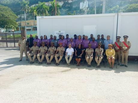 Dr. Horace Chang, Minister of National Security (centre) shares a celebratory moment with course facilitators, and graduates of the Articulated Truck Driving training course at the Caribbean Military Technical Institute’s  graduation ceremony on December