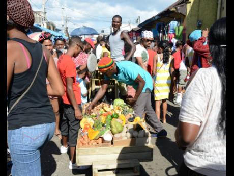 In this 2014 Christmas Eve photo, people shop at the Grand Market in Linstead, St Catherine. Currently, reasonably priced, nutritious food is beyond the reach of the minimum-wage, working-poor majority of Jamaicans. 