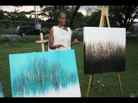 Melissa Preddie, founder and owner of Aviola Accessories poses with her paintings at the first staging of Jamaica Art and Gift Festival on Sunday November 27, at Murray’s Fish and Jerk, Clarendon Park, Clarendon.