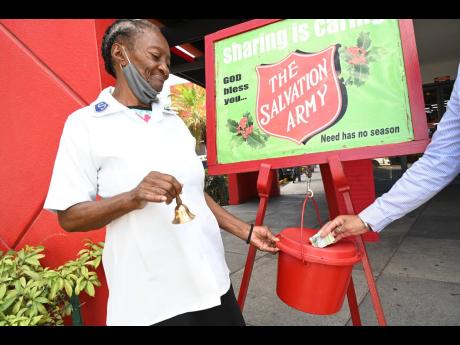 Hyacinth Carr welcomes donations to The Salvation Army’s Christmas Kettle outside Rapid True Value on Constant Spring Road Monday.