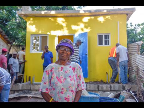 Lurlene Dawson, visits the site of the construction of her new home as volunteers from the Shortwood District of Seven-Day Adventist Church work in the background.