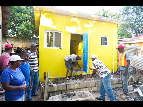 Members of the Shortwood District of Seventh-Day Adventist Church work to complete a house in Grants Pen, St Andrew, for handover to Lurlene Lawson, a senior of the church community.