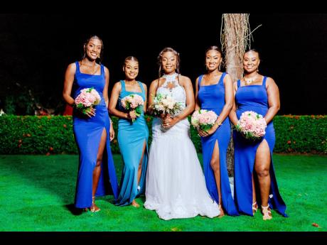 The bridesmaids stand by their beautiful bride’s side, dressed in shades of blue.