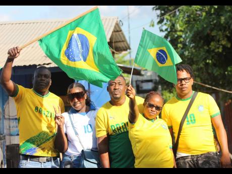 From left: Claude, Googie, Balla Bwoy, Keisha and Kyle celebrate Brazil’s victory over South Korea across the road from Aunties Hot Spot in Old Harbour Bay.  