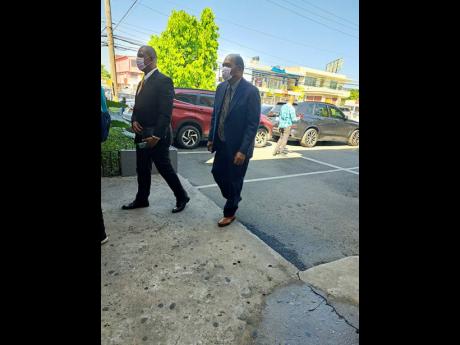 Antigua Director of Public Prosecutions Anthony Armstrong (right) and his attorney-at-law, Hugh Wildman, walk towards the Kingston and St Andrew Parish Court in Half-Way Tree.