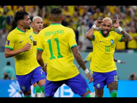 Brazil’s Neymar (right) celebrates with team mates after scoring his side’s second goal during the World Cup round of 16 match between Brazil and South Korea at the Education City Stadium in Al Rayyan, Qatar yesterday.