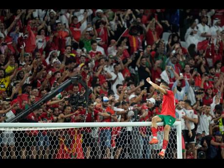Morocco’s Jawad El Yamiq climbs on to the crossbar as he celebrates his team’s victory during the World Cup round of 16 football match between Morocco and Spain, at the Education City Stadium in Al Rayyan, Qatar, yesterday.