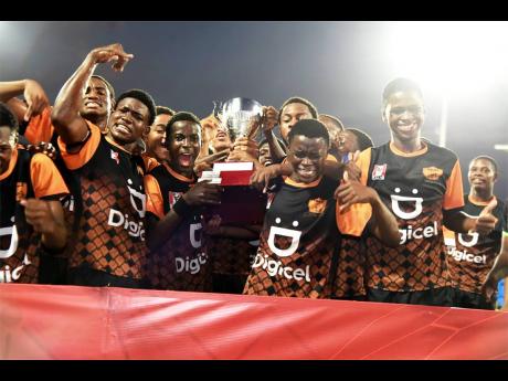 Tivoli High’s players celebrate after winning the Walker Cup KO trophy at Sabina Park on Saturday. 