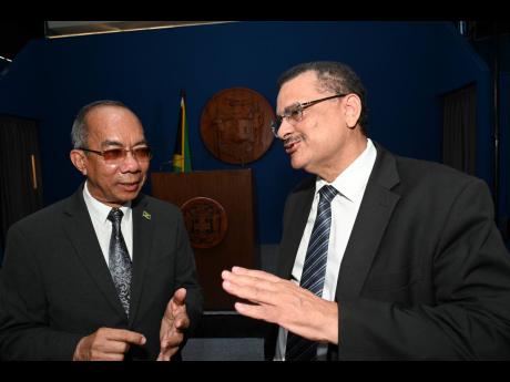 Attorney General Dr Derrick McKoy (right) is seen with Dr Horace Chang, the minister of national security, at a Jamaica House press conference on November 15. 