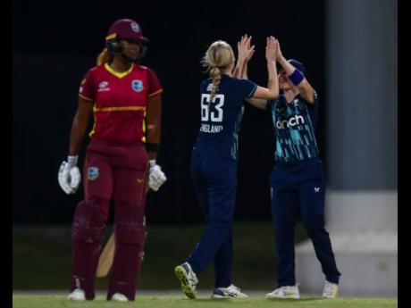 West Indies’ Hayley Matthews (left) walks away as Lauren Bell (centre) celebrates taking her wicket during the first game of a three-match One-Day International Series against England at the Sir Vivian Richards Cricket Ground in Antigua on Sunday.