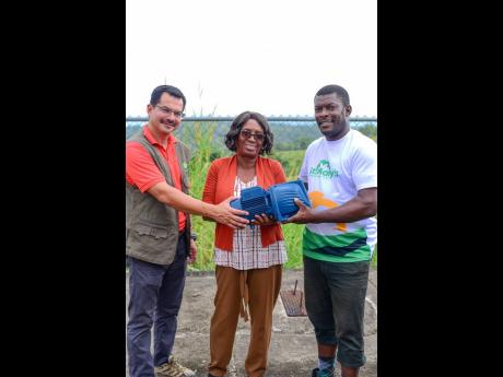 From left: JP Farms General Manager Mario Figueroa, Pringle Home for Children Director Jeanette Rose-Bryan and electrician Gairy Evelyn share a moment just before the installation of a new water pump donated to the Pringle Home by JP Farms on November 19 i