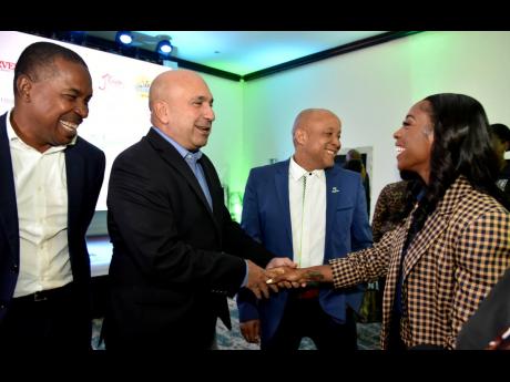 Olympic and World champion Shelly-Ann Fraser-Pryce is greeted by Christopher Zacca, president and CEO at Sagicor Group Jamaica Limited, during the launch of the 25th Sagicor Sigma Legacy Run at The Jamaica Pegasus hotel on Tuesday. Dr Carl Bruce (left), me
